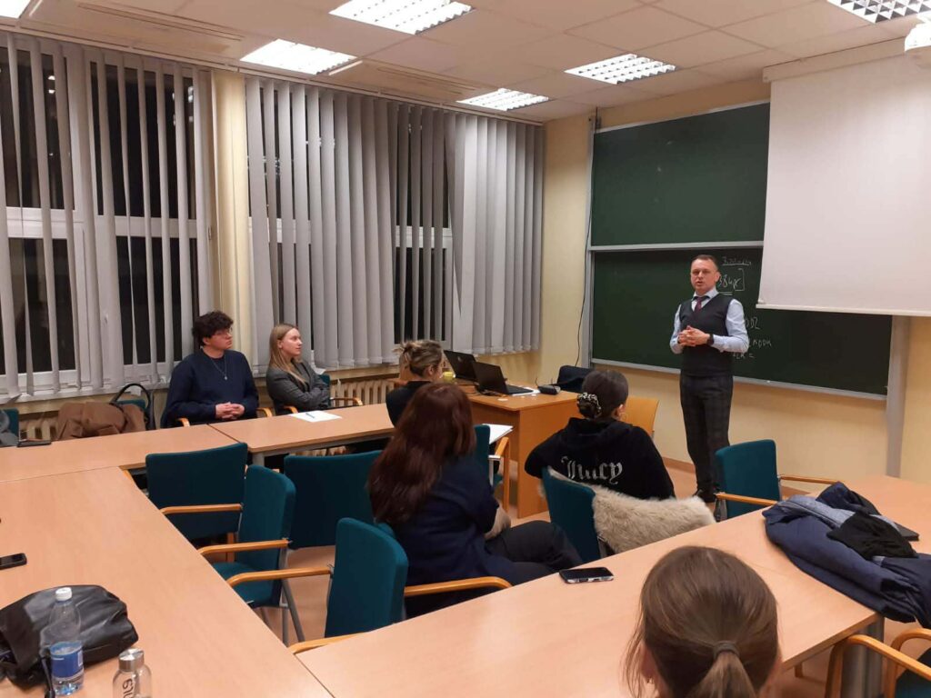 Mężczyzna wygłasza wykład dla grupy studentów