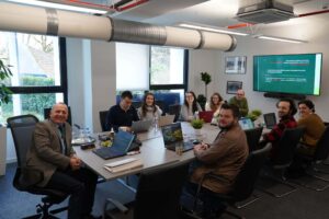 prof. Czubik prowadzi wykład, siedzi przy stole w otoczeniu studentów