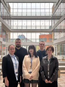 grupa studentów stoi w budynku uniwersytetu