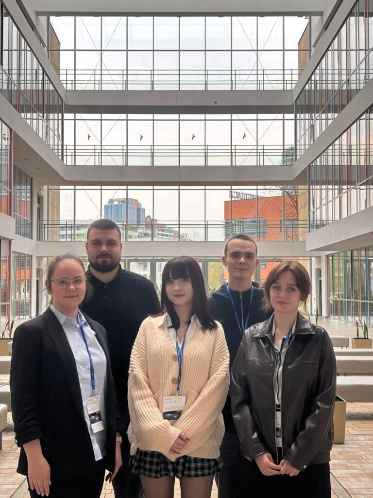 grupa studentów stoi w budynku uniwersytetu