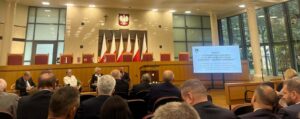grupa osób siedzi w Trybunale Konstytucyjnym i dyskutuje