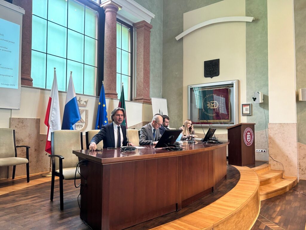 trzej mężczyźni w garniturach i kobieta za stołem konferencyjnym
